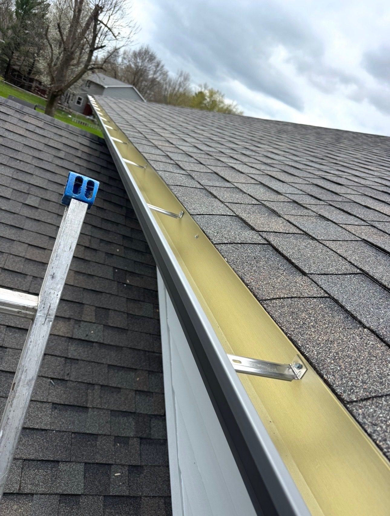 Gutter guard support brackets installed along a roof edge
