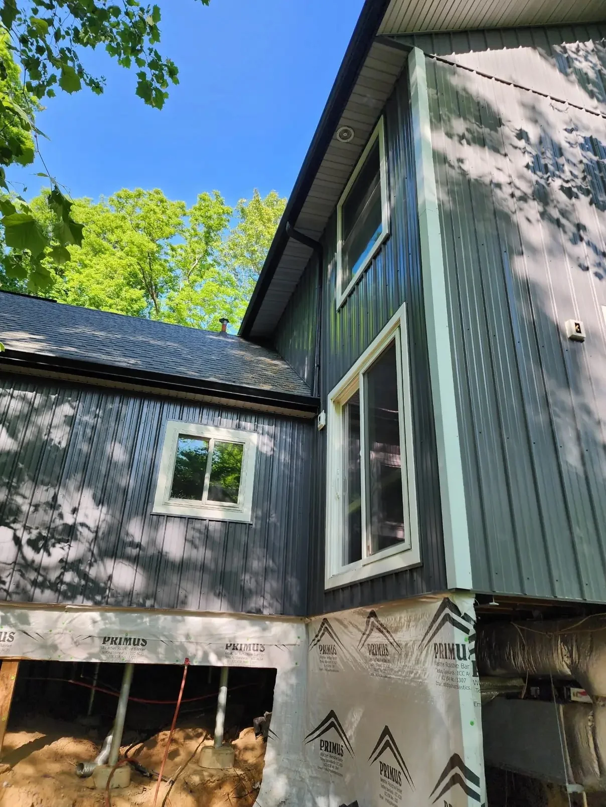 Tall exterior wall with dark gutter line and downspout
